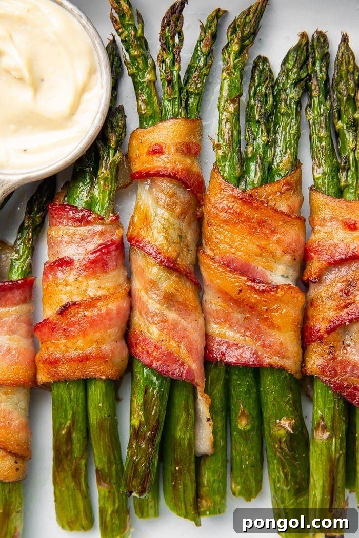 Bacon-wrapped asparagus stalks placed vertically in a row