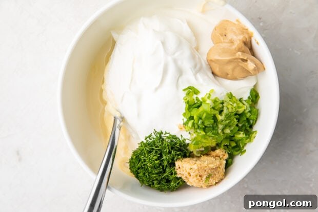 Ingredients for horseradish sauce laid out in a white bowl, ready to be combined.