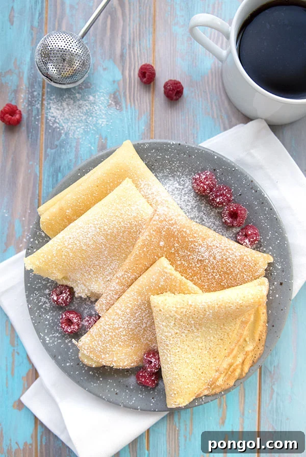 Delicate Almond Flour Crepes neatly folded in a blue bowl, ready for filling.
