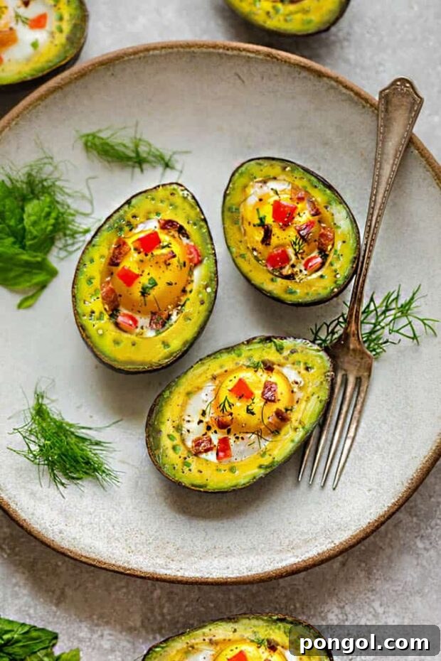 Colorful Avocado Egg Boats filled with eggs and fresh veggies on an off-white plate.