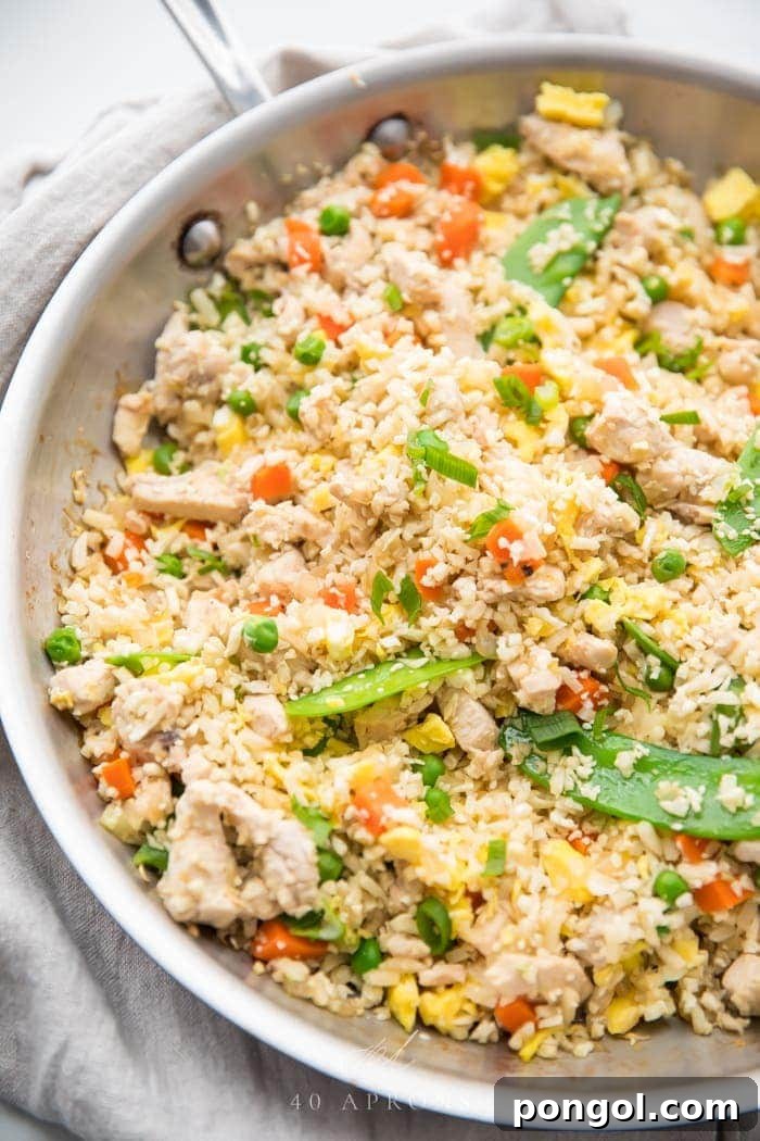 New Year, New You: 65 Satisfying Whole30 Meals 31 A large white bowl brimming with cauliflower fried rice, tender chicken, and various vegetables.