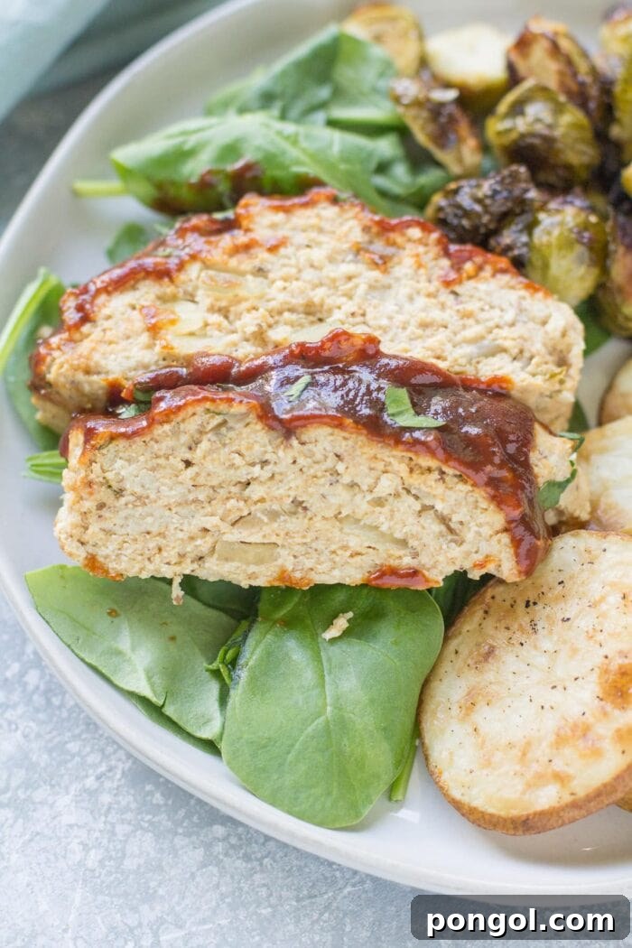 New Year, New You: 65 Satisfying Whole30 Meals 39 Whole30 barbecue chicken meatloaf with a side of fresh greens on a white plate.