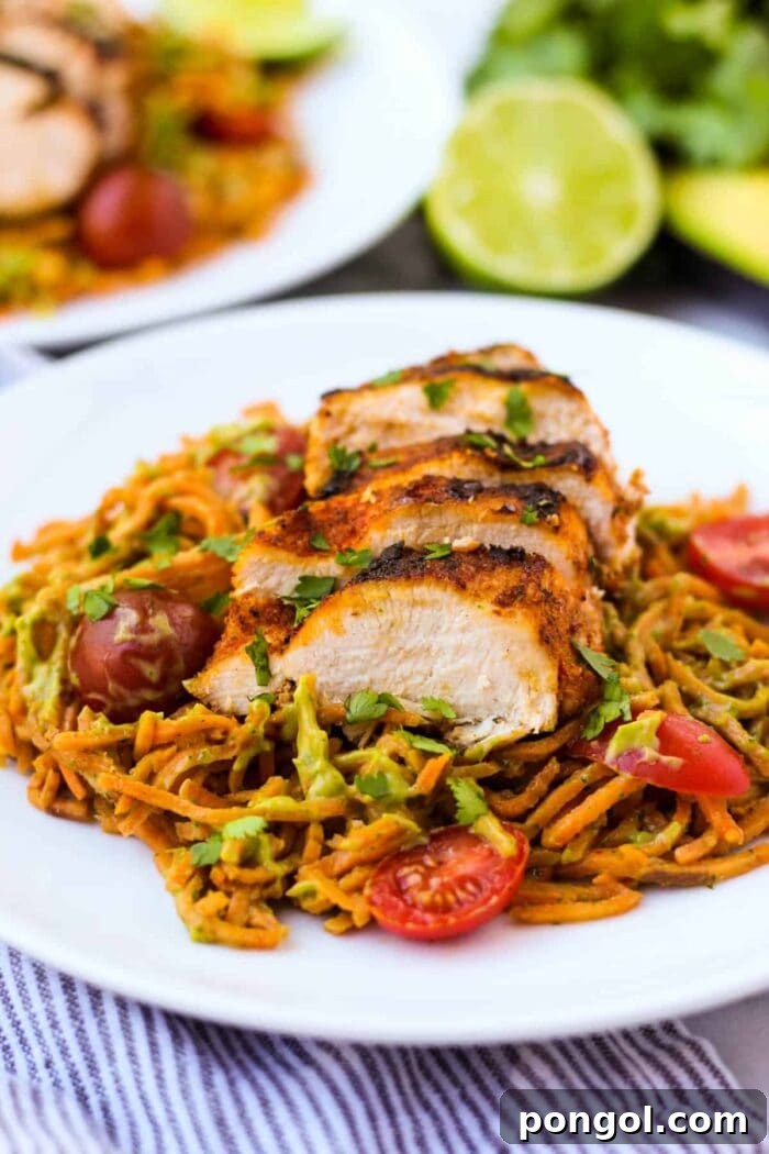 New Year, New You: 65 Satisfying Whole30 Meals 44 Whole30 chili dusted chicken with sweet potato noodles and a creamy avocado sauce on a white plate.