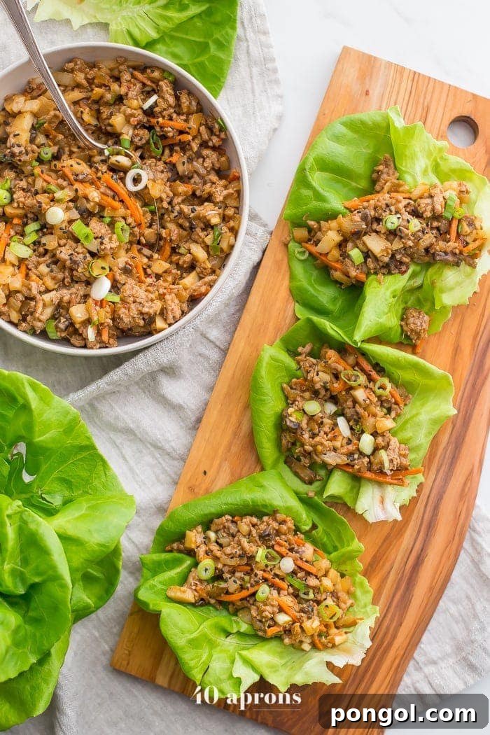 New Year, New You: 65 Satisfying Whole30 Meals 49 Delicious Whole30 Asian lettuce wraps, artfully arranged on a wooden platter.