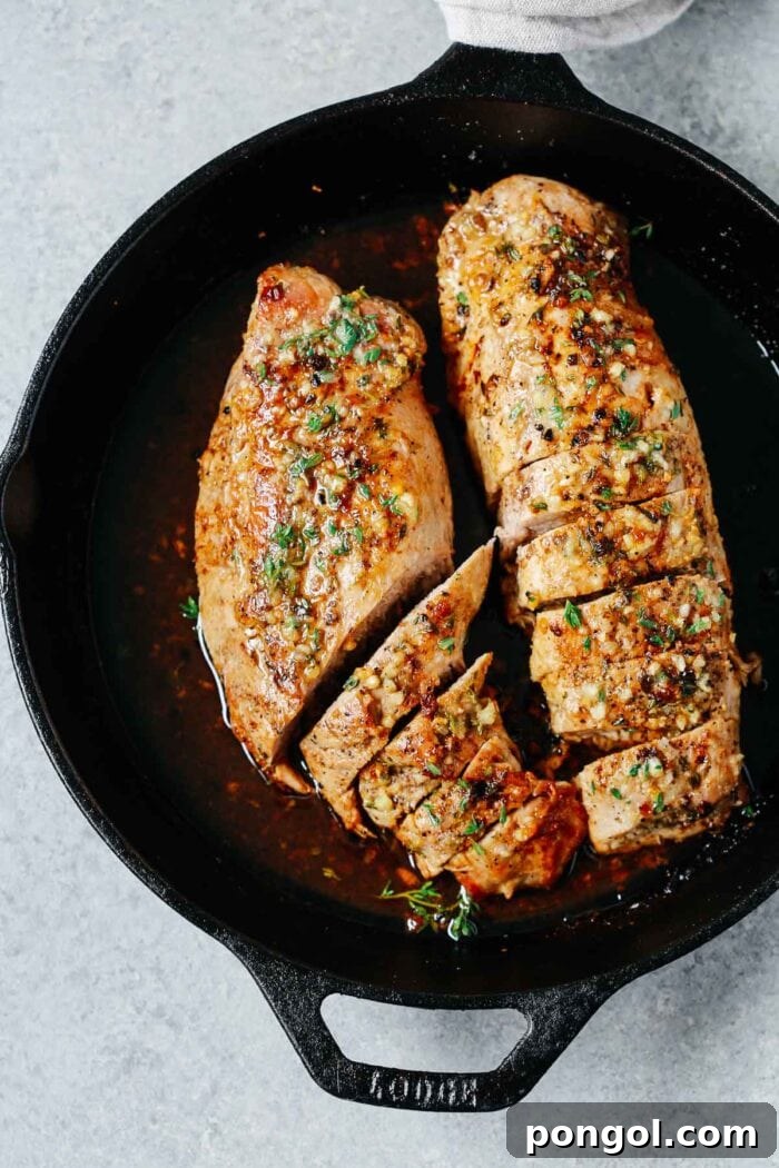 New Year, New You: 65 Satisfying Whole30 Meals 50 A cast iron pan holding two large, perfectly marinated pork tenderloins with garlic butter and seasonings.