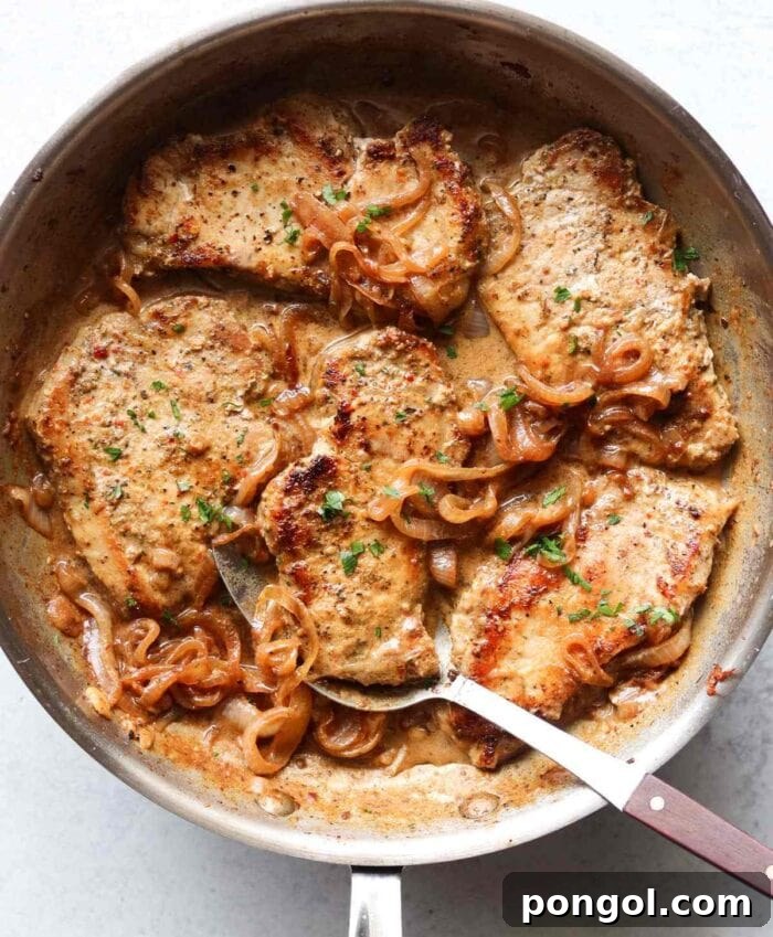 New Year, New You: 65 Satisfying Whole30 Meals 52 A large skillet containing four savory pork chops and onions, swimming in a delicious sauce.