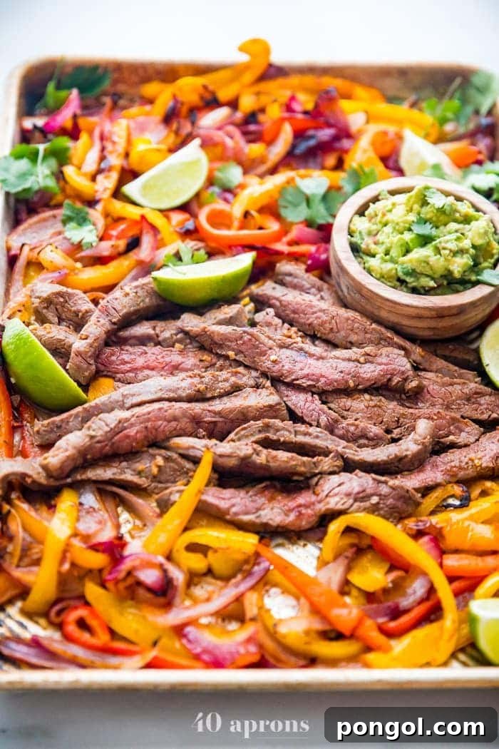 New Year, New You: 65 Satisfying Whole30 Meals 57 Sizzling fajita peppers and steak arranged on a convenient sheet pan, ready for a delicious meal.