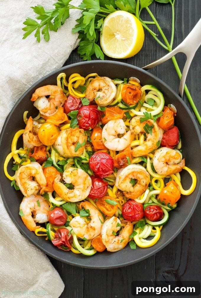 New Year, New You: 65 Satisfying Whole30 Meals 64 A cast iron skillet filled with zucchini zoodles, succulent shrimp, and roasted tomatoes, garnished with fresh lemon.