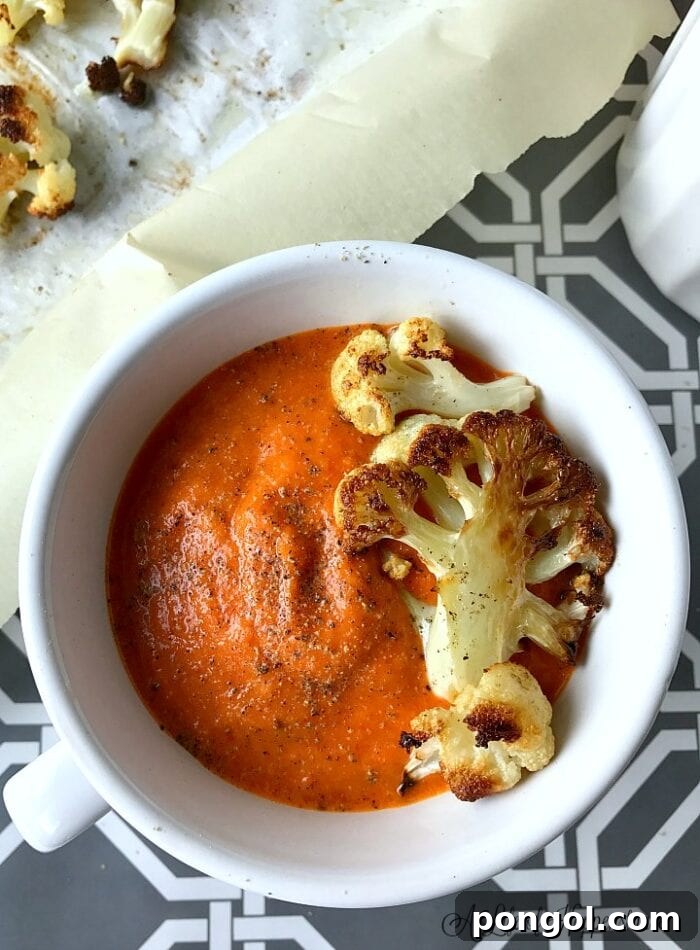 New Year, New You: 65 Satisfying Whole30 Meals 8 A white bowl of rich roasted red pepper soup, topped with a piece of roasted cauliflower.