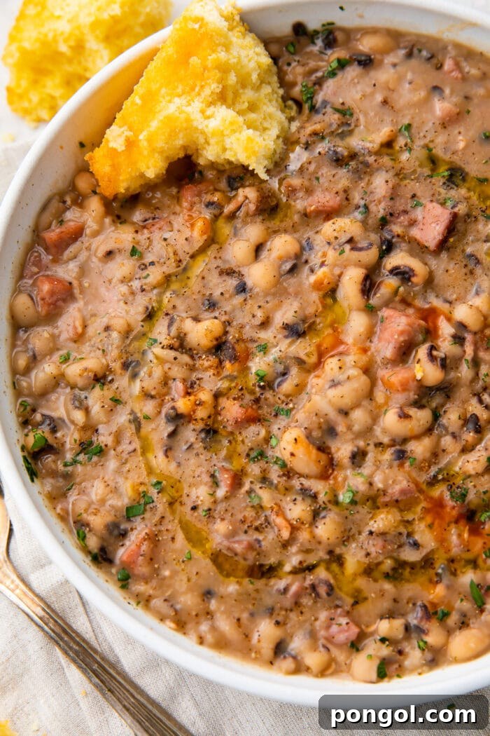 Instant Pot black-eyed peas served in a white bowl with a slice of cornbread on the side, ready to be enjoyed.