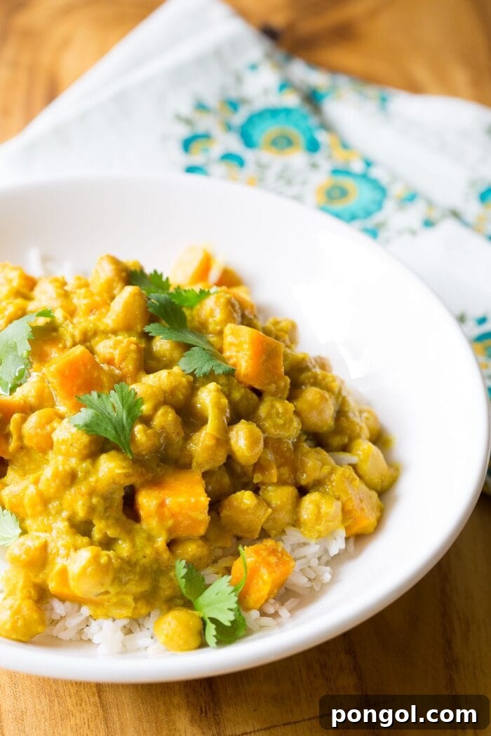 Vegetarian slow cooker chickpea curry recipe in a white bowl on a wooden table