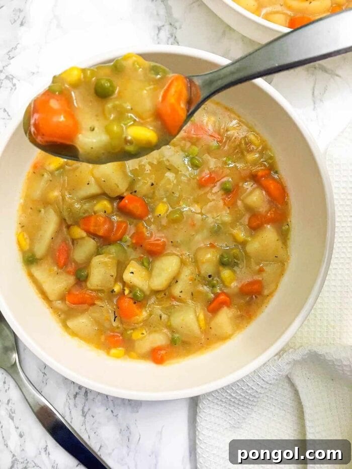 Vegetarian slow cooker pot pie stew in a white bowl with a spoon