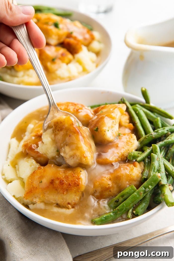 A close-up view of the Whole30 fried chicken and mashed potato bowl, highlighting the crispy texture of the chicken, the smoothness of the mashed potatoes, and the rich gravy.