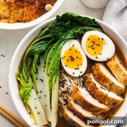 A white bowl of keto ramen with shirataki noodles, ramen eggs, chicken, and bok choy