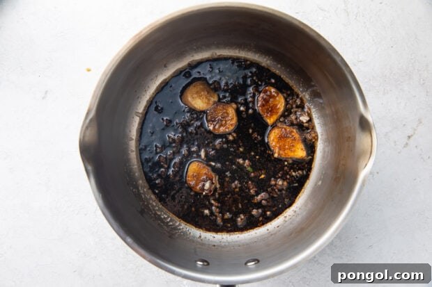 Garlic, ginger, oil, and soy sauce in a large silver pot