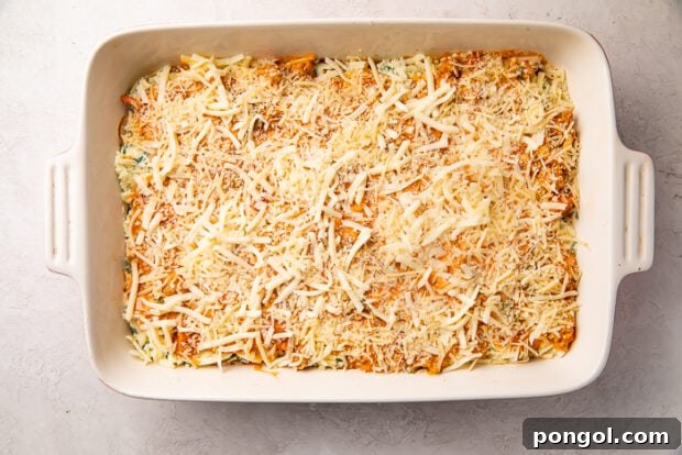 The Keto Lasagna Revelation 12 Unbaked keto lasagna in a white ceramic baking dish, ready for the oven with all its layers.