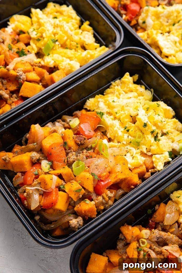 Six reusable meal prep containers filled with Whole30 compliant breakfast hash and scrambled eggs, ready for the week.