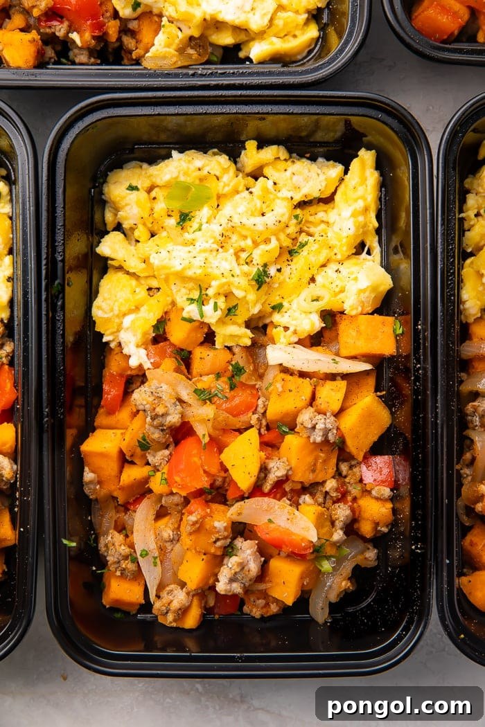 Reusable meal prep trays with sweet potato, scrambled eggs, and sausage for a whole30 breakfast, ready to be stored.