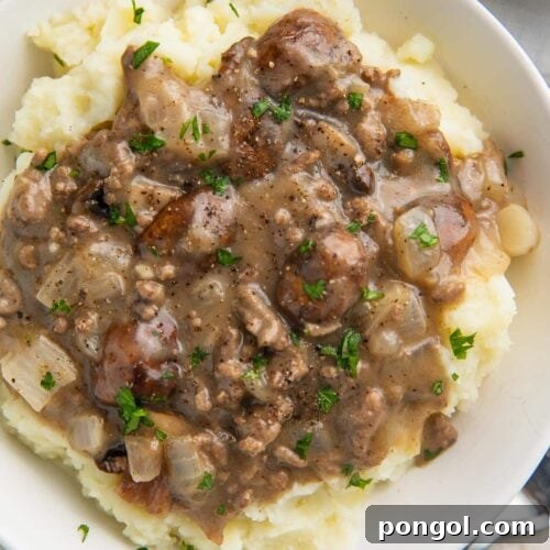 Close up overhead image of beef stroganoff on top of mashed potatoes
