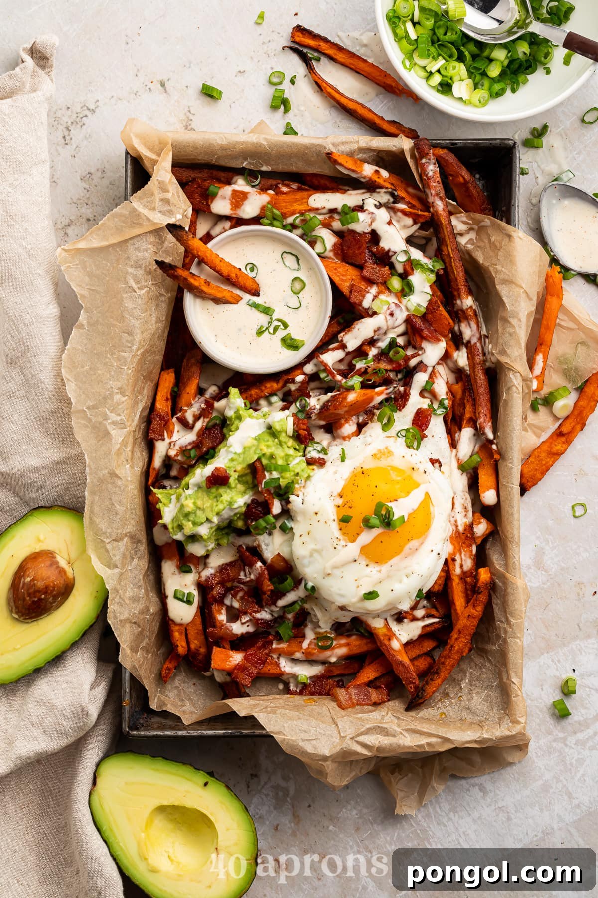 Whole30 Loaded Sweet Potato Fries in a parchment paper lined dish, shot from overhead
