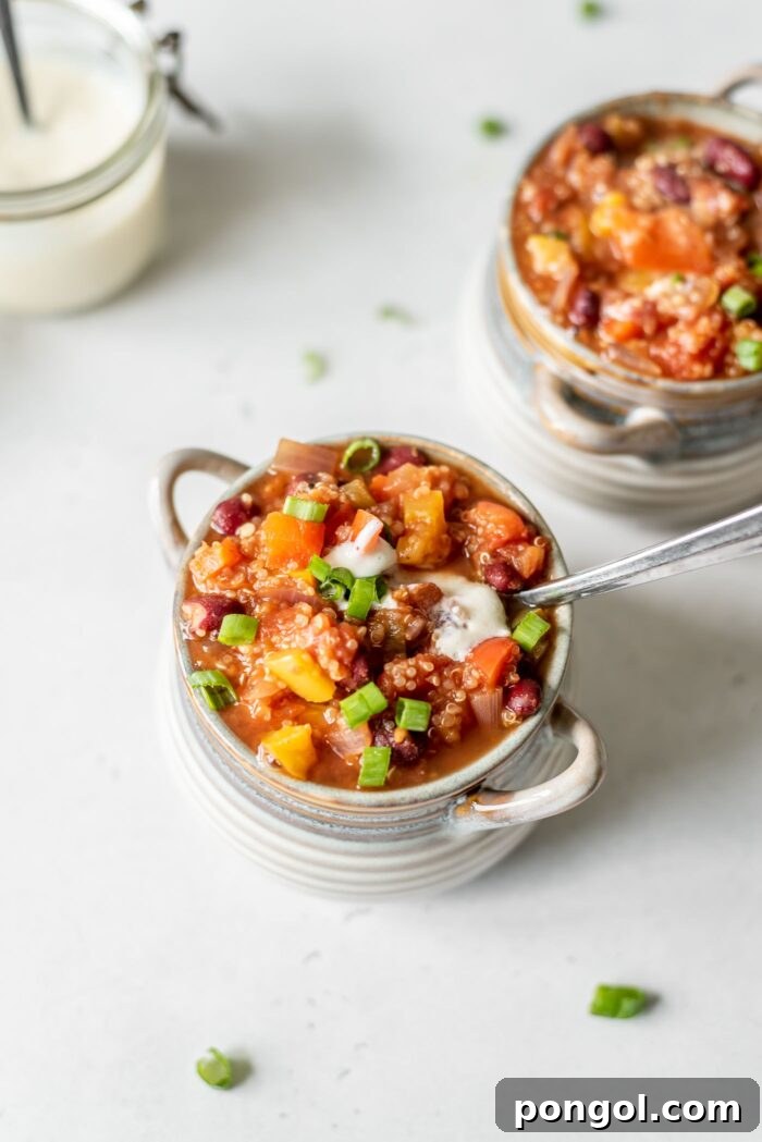 Two small, rustic bowls filled with rich and flavorful quinoa chili, perfectly portioned for a comforting vegan meal.