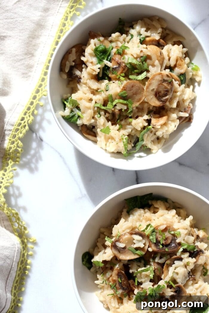 One and a half bowls of creamy mushroom risotto, beautifully plated on a white table, highlighting its rich texture.