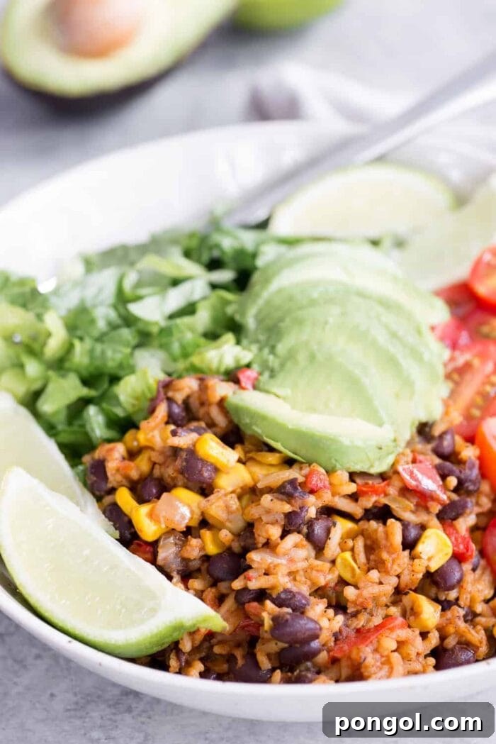 A close-up view of a vibrant vegan Mexican burrito bowl, layered with fresh ingredients and bursting with color and flavor.