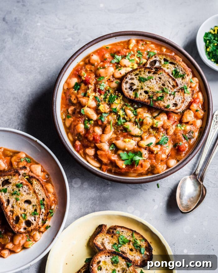 A white bowl showcasing a rustic and flavorful vegan white bean chili, presented on a light, minimalist background.
