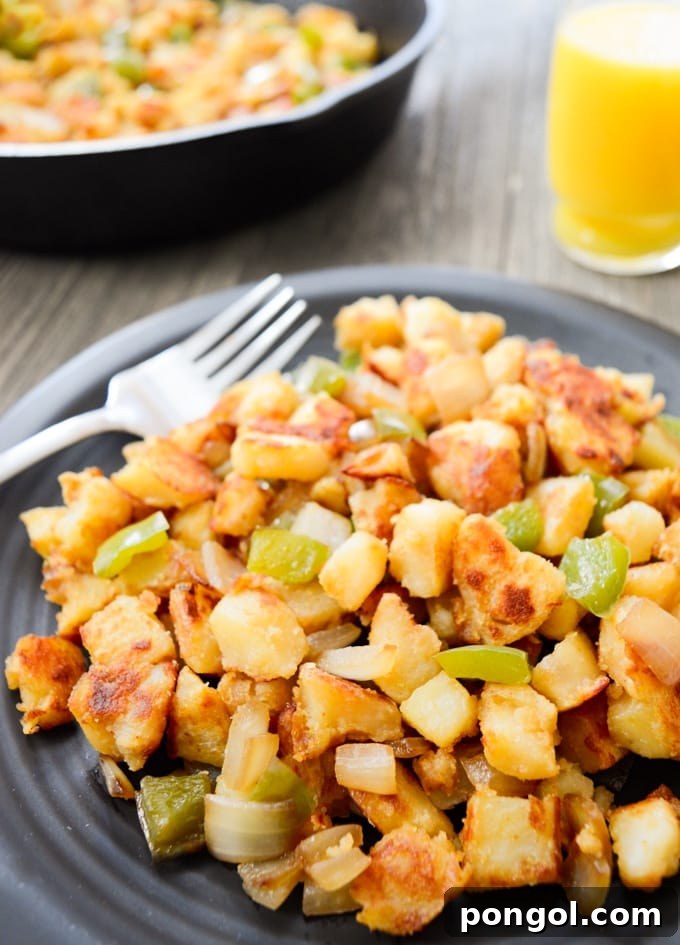 A grey plate holding golden Instant Pot breakfast potatoes with colorful bell peppers, perfectly seasoned and ready to serve.