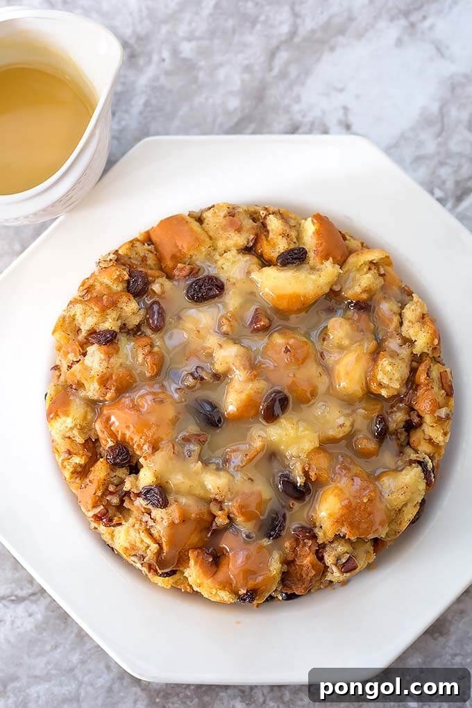 A pristine white plate holding a serving of fluffy vegan bread pudding, perfectly complemented by a rich sauce, all made in the Instant Pot.