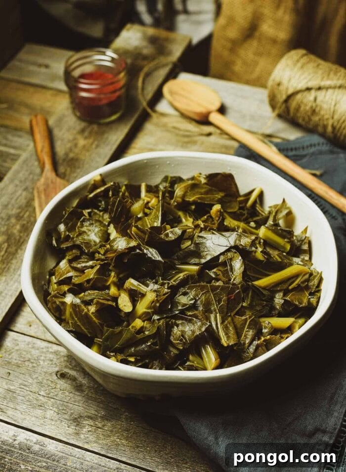 Hearty vegan Instant Pot collard greens served in a unique sage-colored bowl, accompanied by a wooden spoon on a rustic wooden table.
