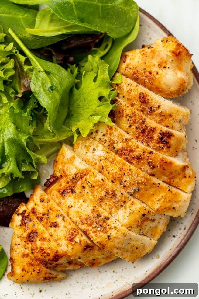 30 Delicious Keto Air Fryer Recipes 15 Air fried chicken breast on a white plate next to a bed of lettuce