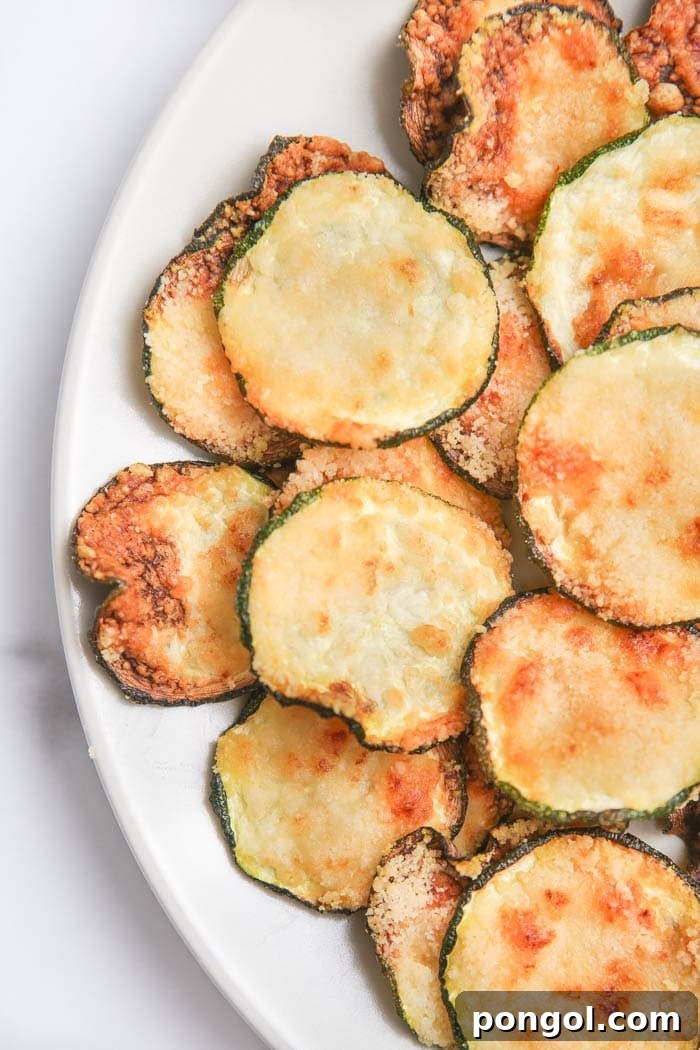 30 Delicious Keto Air Fryer Recipes 21 Air fried zucchini chips on a white plate on a white table