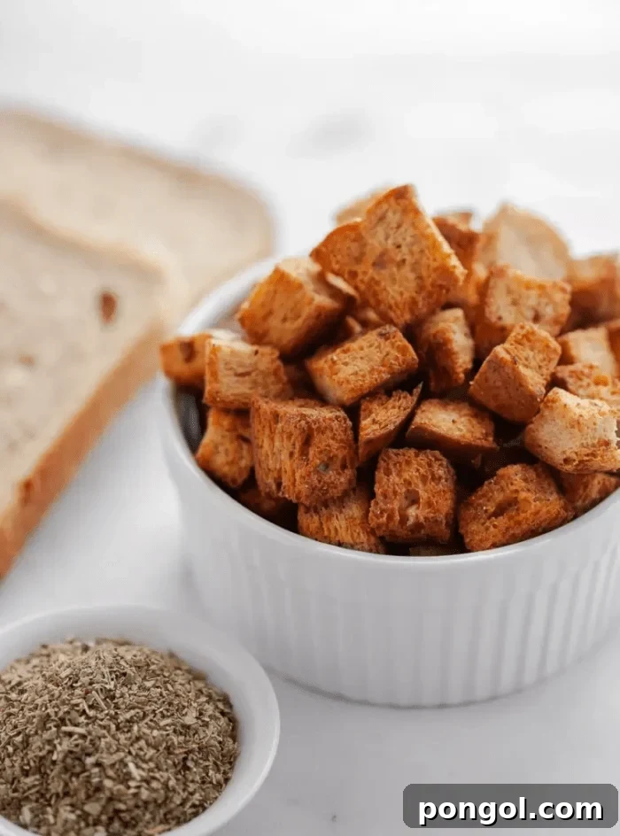 30 Delicious Keto Air Fryer Recipes 22 A white bowl of air fried croutons next to a slice of keto bread