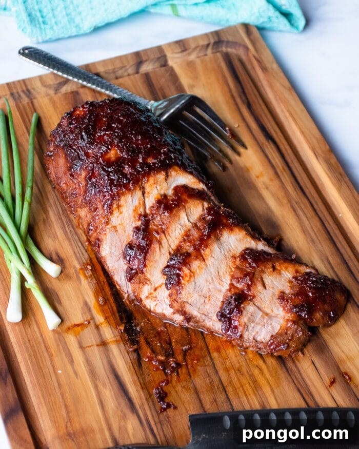 Expertly cut Korean barbecue pork loin on a rustic wooden cutting board, garnished with fresh green onions