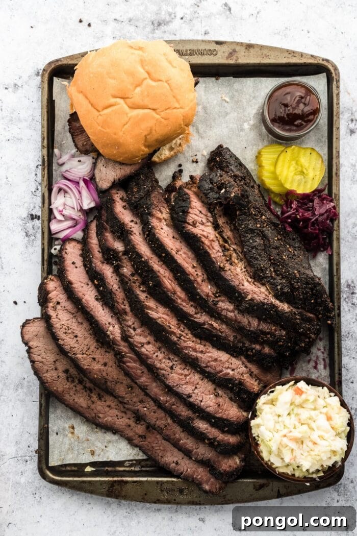 Perfectly sliced sous vide brisket on a sheet pan, accompanied by fresh bread and vibrant garnish