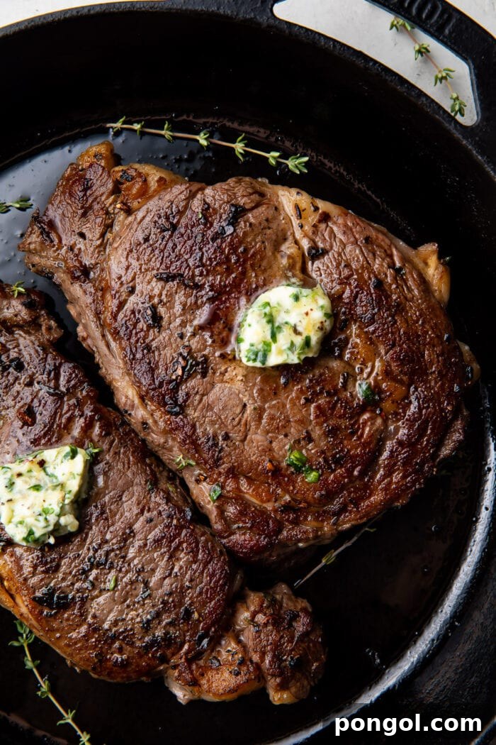 Sous vide ribeye with garlic herb butter in a cast iron skillet, showcasing the ideal setup for achieving a perfect sear.