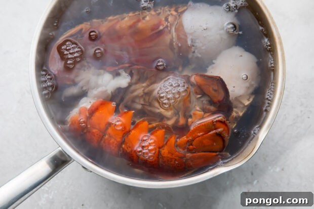 Boiling lobster tails in a large silver pot.