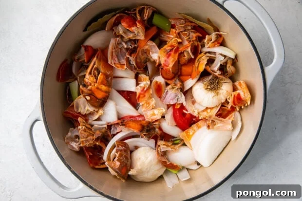 Lobster shells, onion, garlic, and vegetables in a large pot.