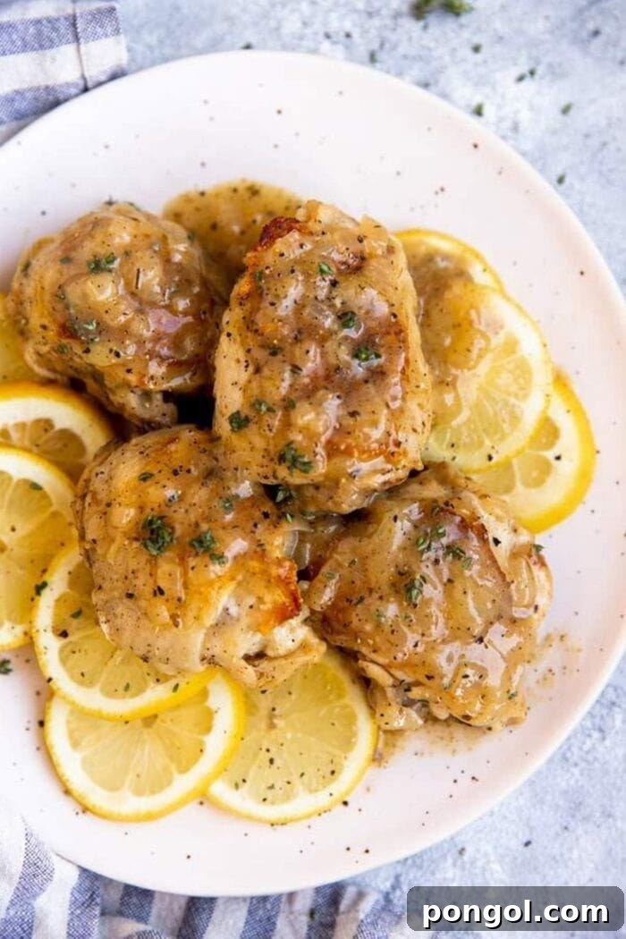 Chicken on top of slices of lemon, on a white plate
