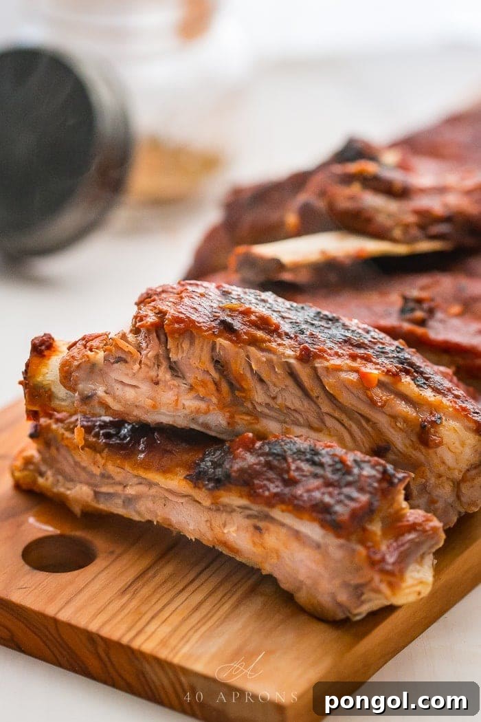 Baby back ribs cut apart on a wooden cutting board