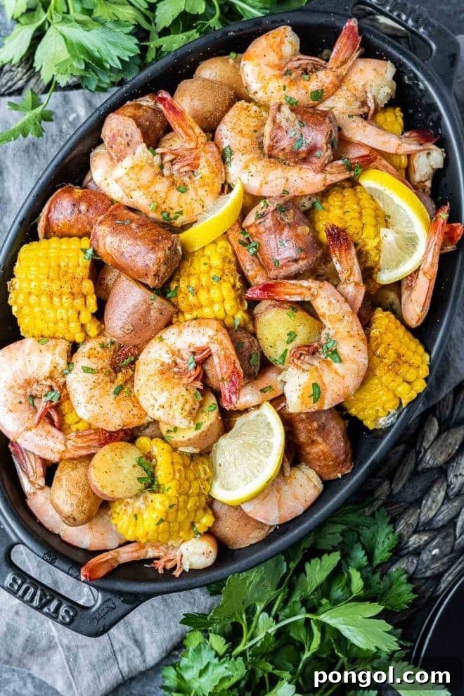 Instant Pot shrimp boil - shrimp, potatoes, corn, lemon on a black platter