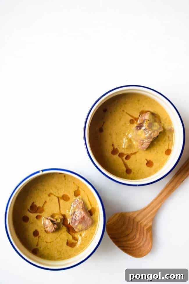 Two bowls of beef and broccoli soup on a white background