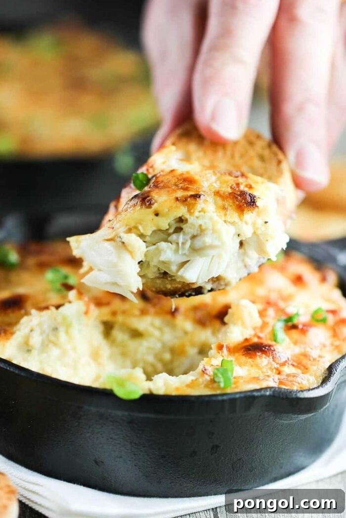 A delectable slice of gratin being carefully removed from a cast iron skillet with a serving spoon.