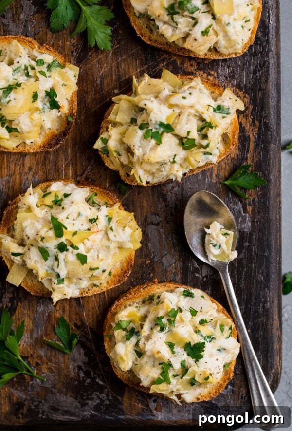 Small crostinis generously topped with a creamy artichoke crab salad, garnished with fresh dill.