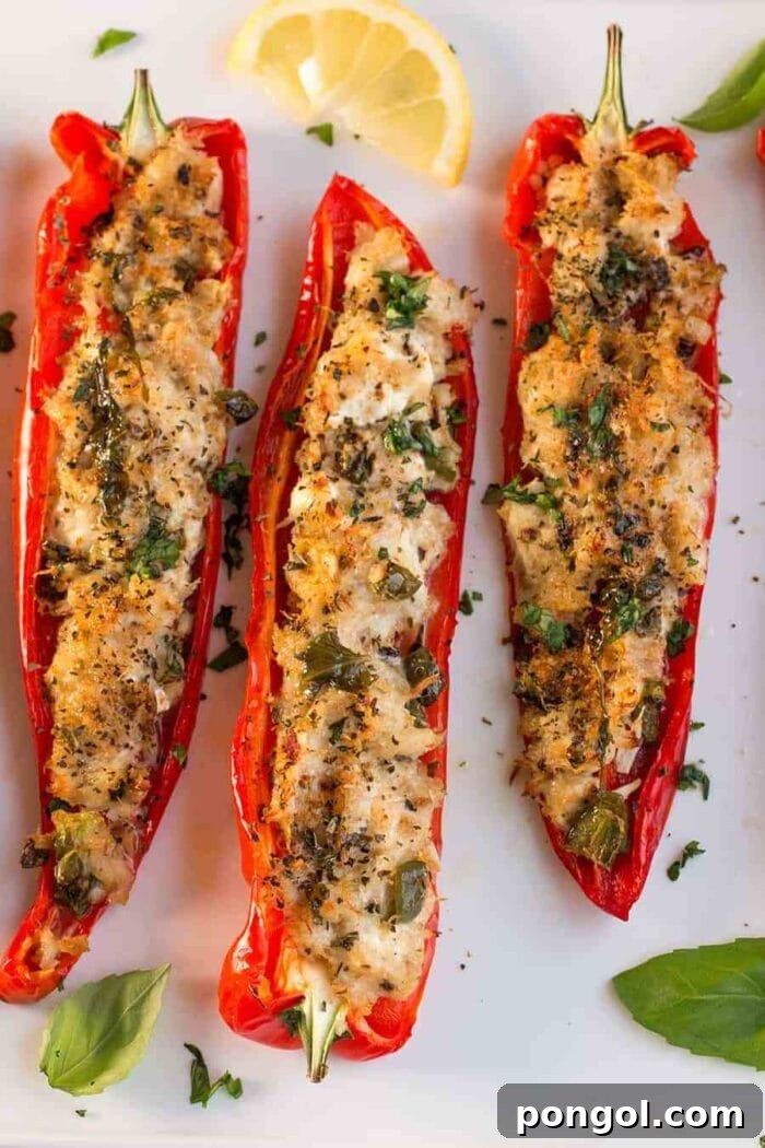 Two halves of red bell peppers, generously stuffed with crab meat and baked to perfection.