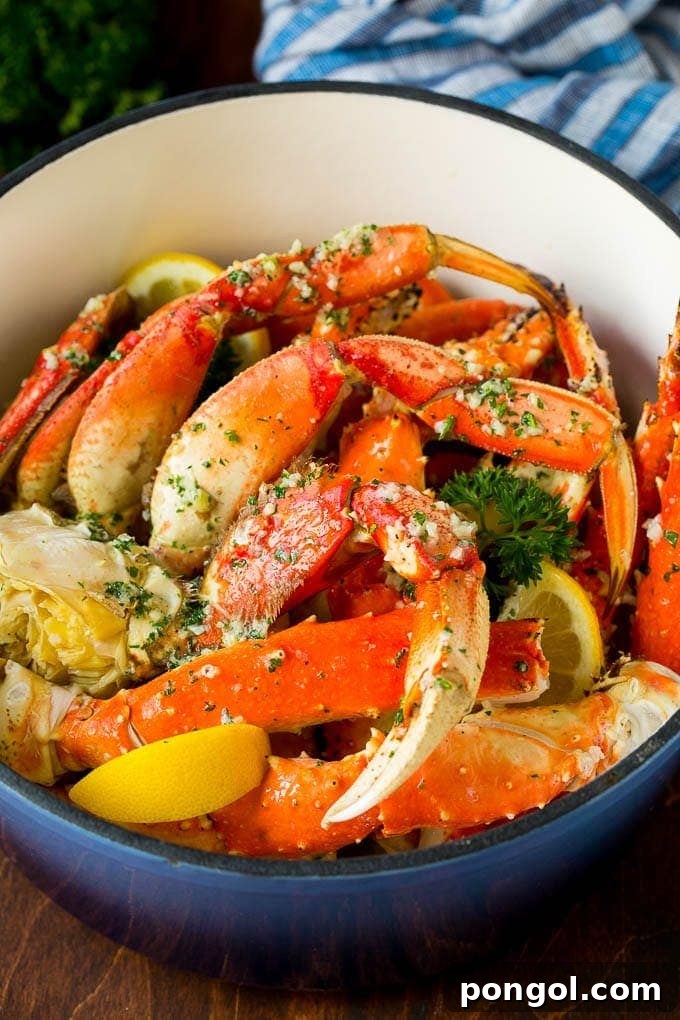A big pot of bright red, steamed crab legs with vibrant yellow lemon wedges, ready to be served.