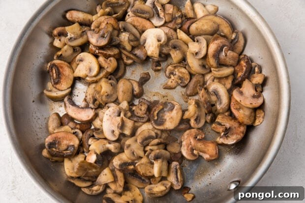 Creamy Wild Mushroom Risotto 6 Mushrooms sautéed to perfection in butter within a shimmering silver saucepan, ready to be set aside for later.