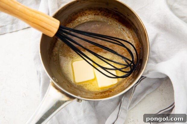 Lemon juice and chilled butter in a silver saucepan with a whisk
