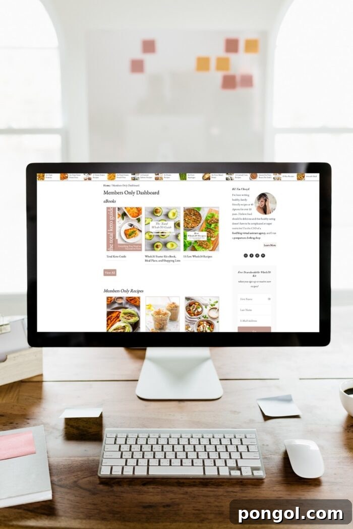 Premium Apron Collection: Forty Pieces 2 40 Aprons Premium membership portal displayed on a desktop computer, set on a stylish wooden desk with natural light from large windows. The screen shows vibrant, healthy recipes and meal plans, inviting users to a seamless culinary journey.